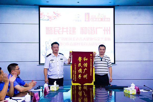 王老吉大健康副总经理翁少全向广州市公安局交警支队赠送“警民携手 和谐广州”锦旗