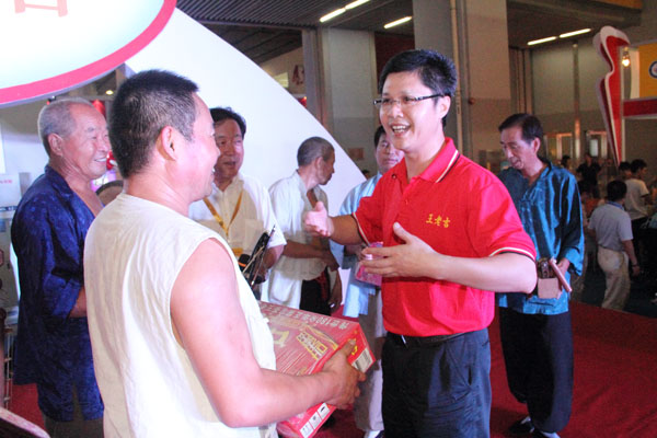 蔡涛总监亲自为辛苦表演的老乡们送上红罐王老吉凉茶，希望能把王老吉“传承历史，走向世界”的精神带给陕西山区的乡民